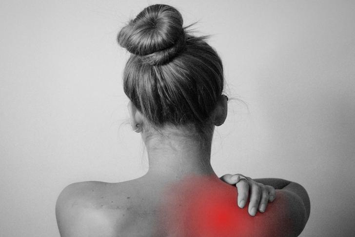 girl holding shoulder in pain